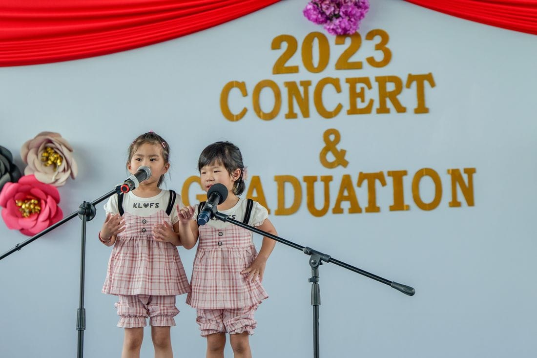 Two children singing at the concert and graduation